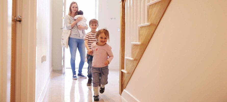 fröhlich laufende Kinder mit Mutter im Vorzimmer